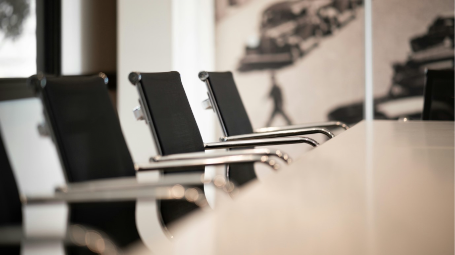 Empty boardroom with modern chairs representing absence from AI ethics discussions